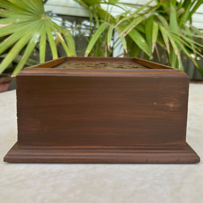 Wooden box on a table with plants in the background