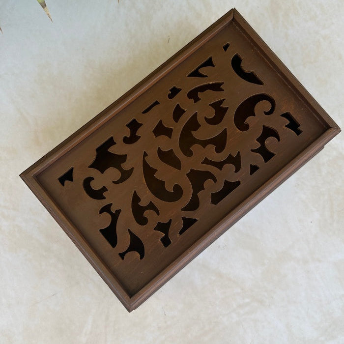 Decorative wooden box top view with intricate cut-out patterns on a light background