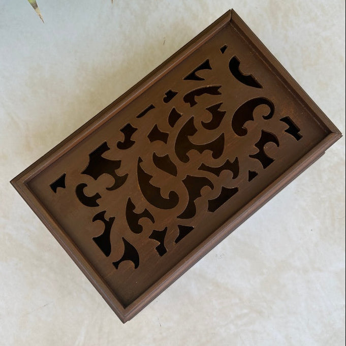 Decorative wooden box top view with intricate cut-out patterns on a light background