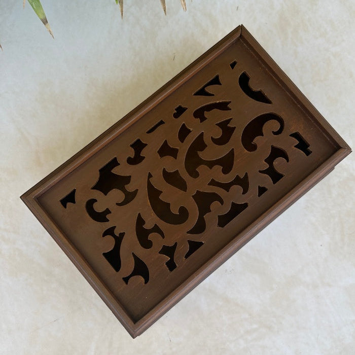 Top view of decorative wooden box with intricate cut-out patterns on a light background