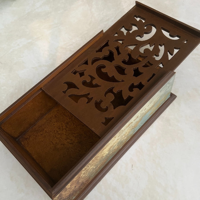 Decorative wooden box with intricate carvings on a light background