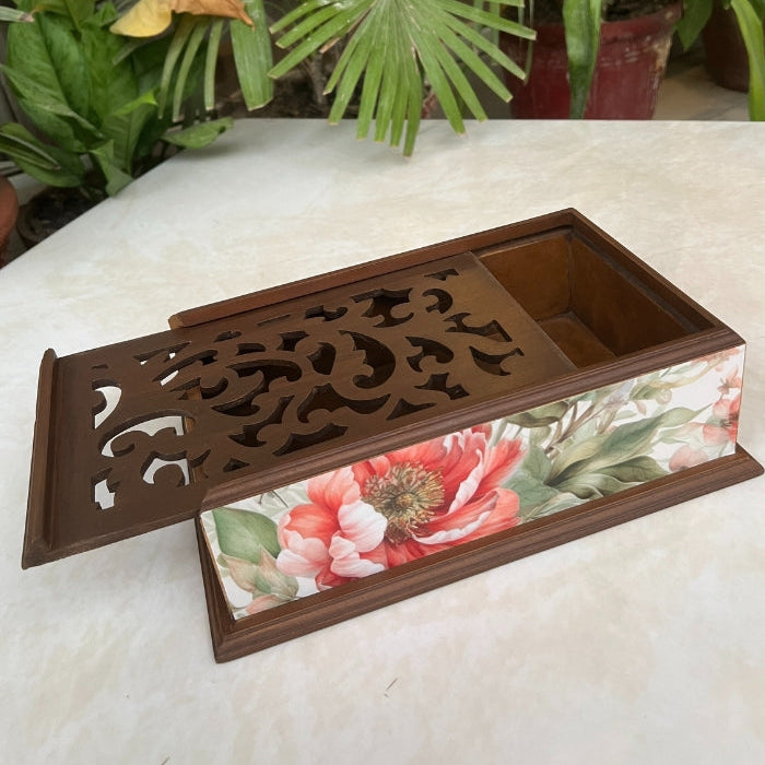 Decorative box with floral design on a white surface with the lid open