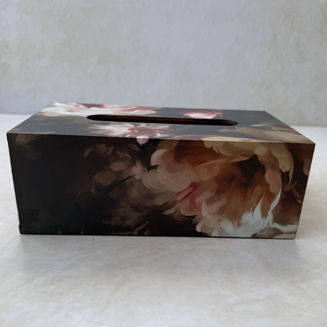 Floral-patterned tissue box cover on a white surface