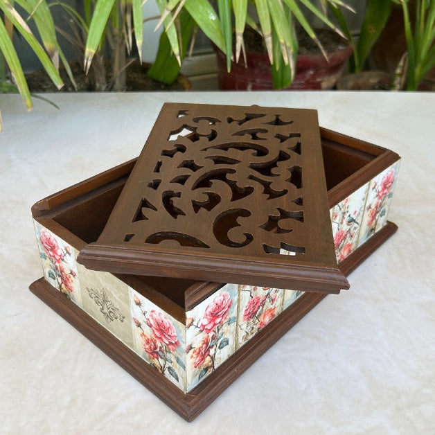Decorative box with floral pattern and intricate lid design on a light surface.