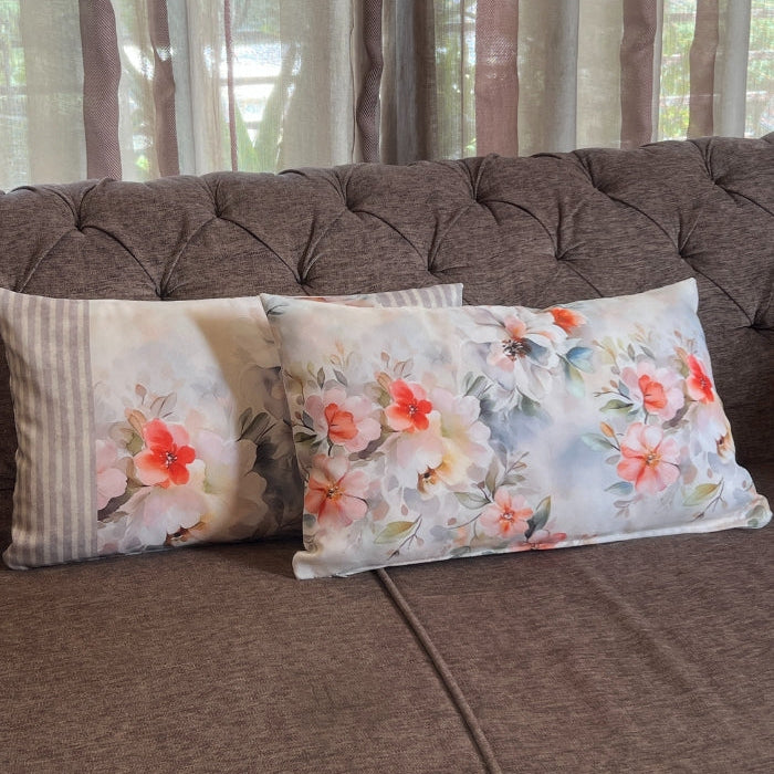 Floral-patterned cushions on a brown sofa with curtains in the background