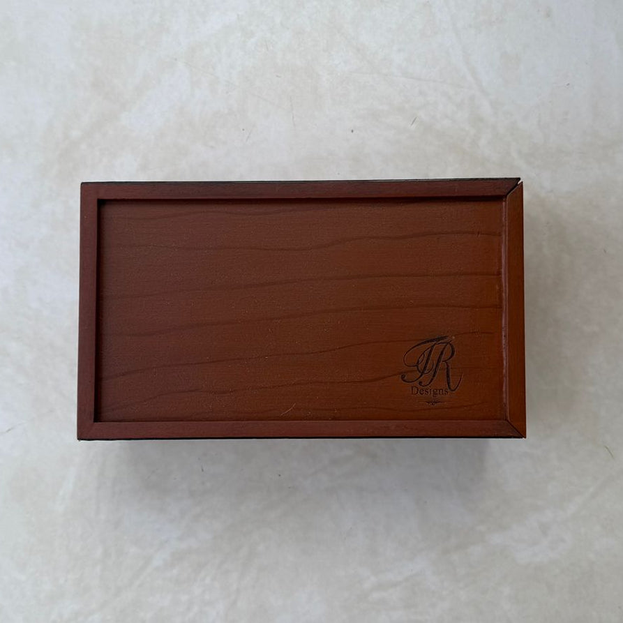 Bottom view of wooden tissue box with a logo on a textured white background