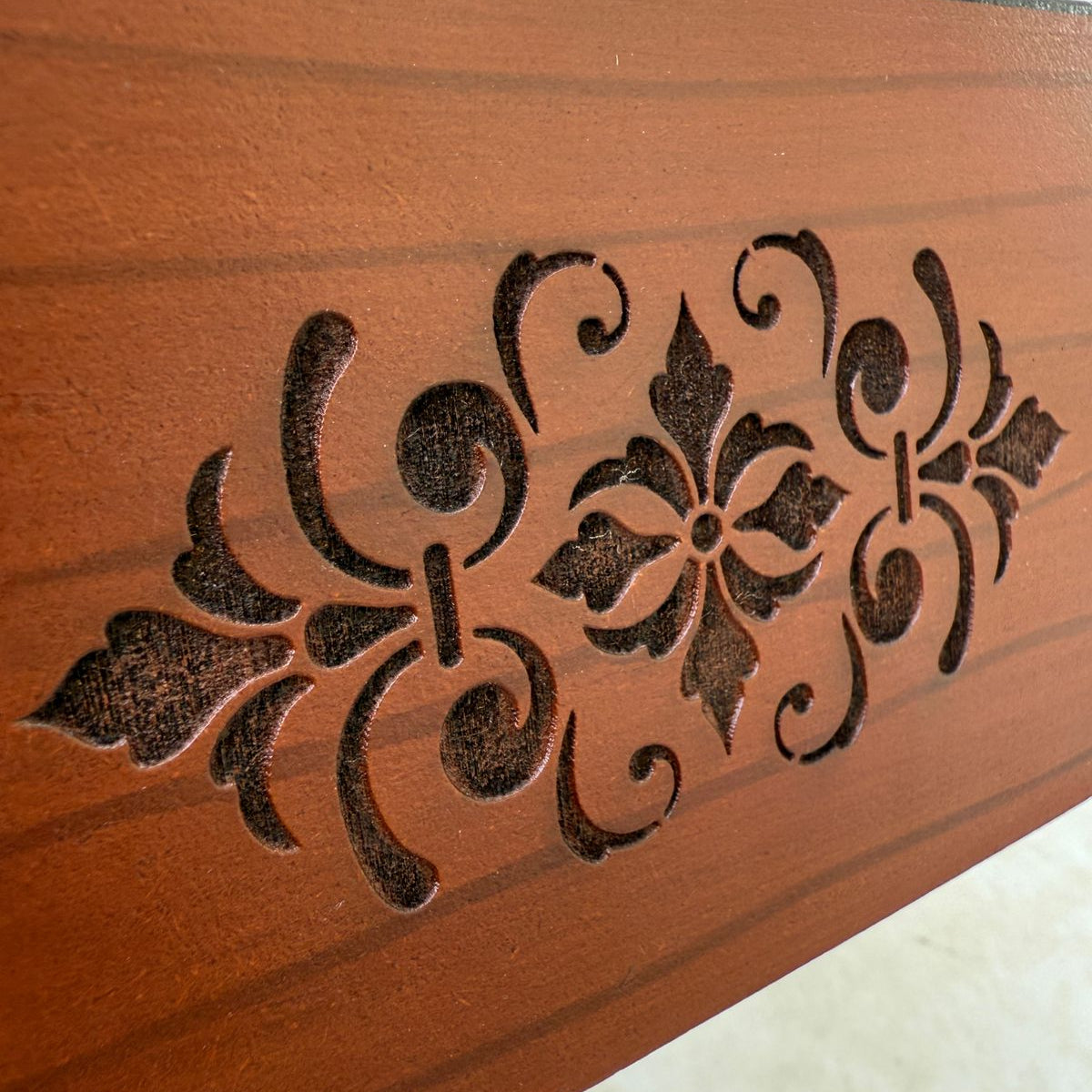 Decorative tissue box with intricate carvings on a plain background