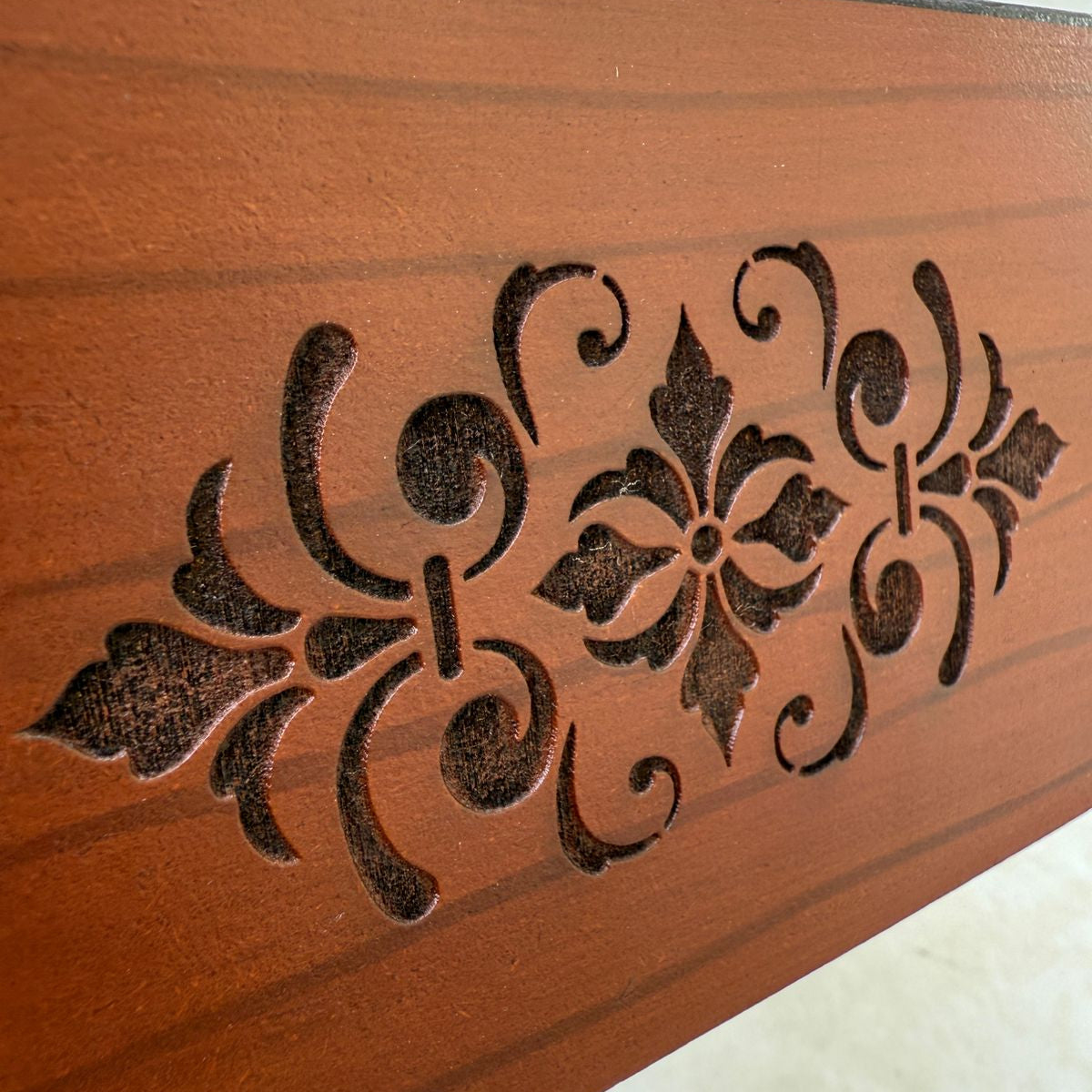 Decorative tissue box with intricate carvings on a plain background